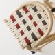 Detail of the red/green woven straps seat on the VIRAGE design barstool in rattan and metal